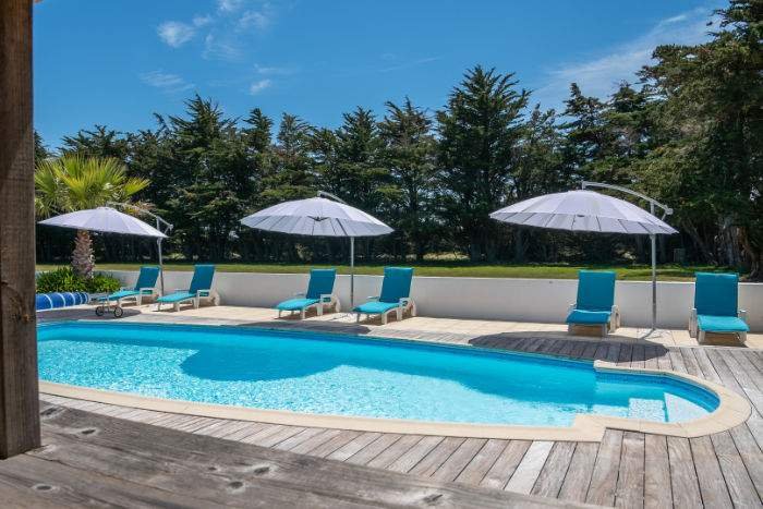 Parasol et transats au bord de la piscine